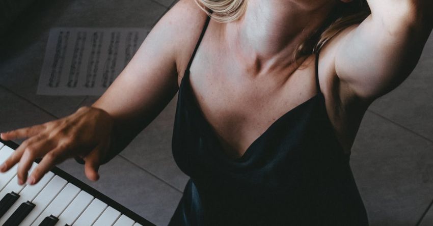 Bluegrass Music - A woman playing the piano in front of a window