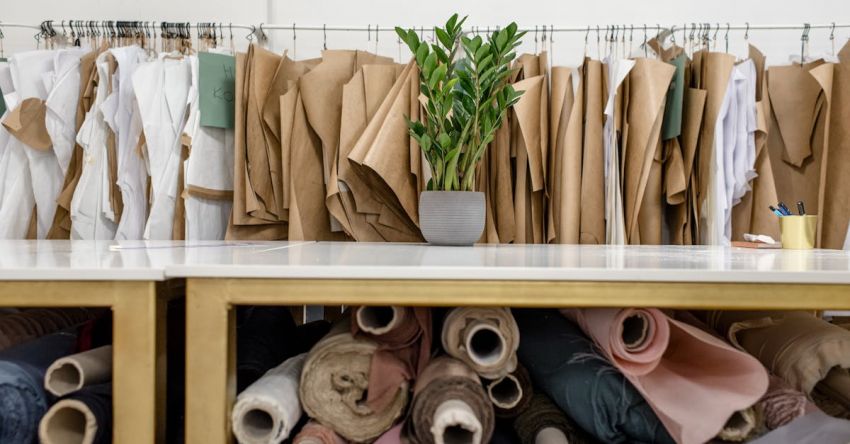 Cotton Industry - Rolls of assorted fabrics and textiles and sewing patterns inside tailor atelier
